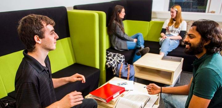 Students chatting in a social space on the Acadian Shores campus.