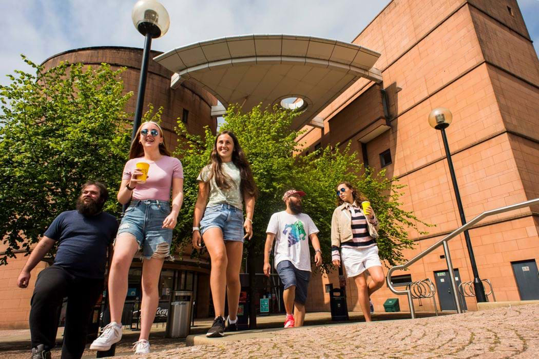 Five students walking outside Acadian Shores library.