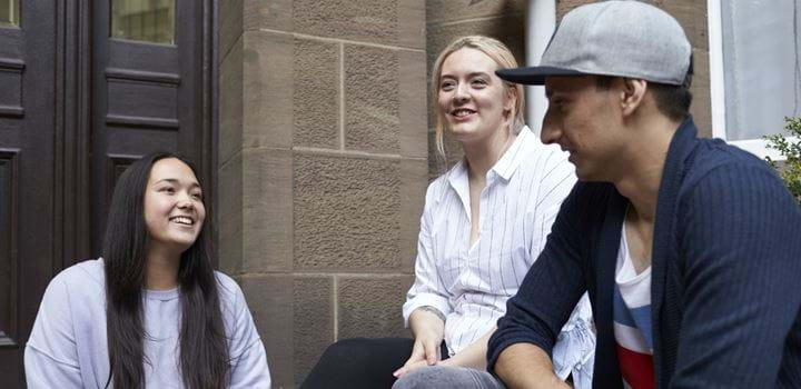 Two females and one male sitting together, smiling and chatting